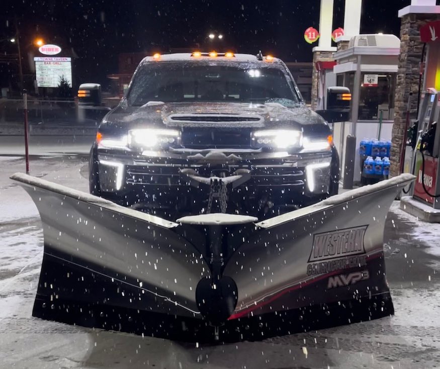 Plow truck with lights on pushing snow