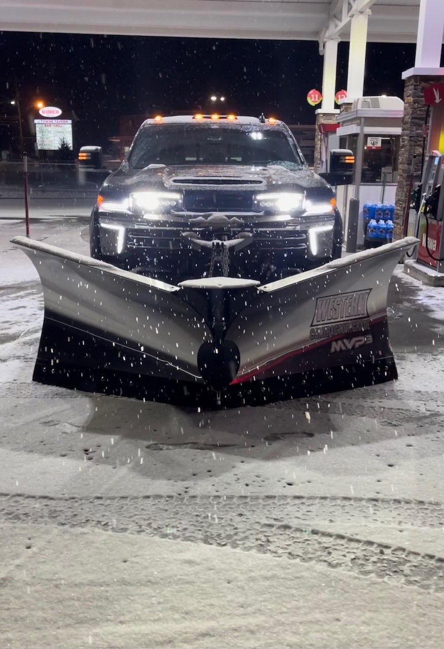 Manente plow truck with a V-plow at night in fresh snow